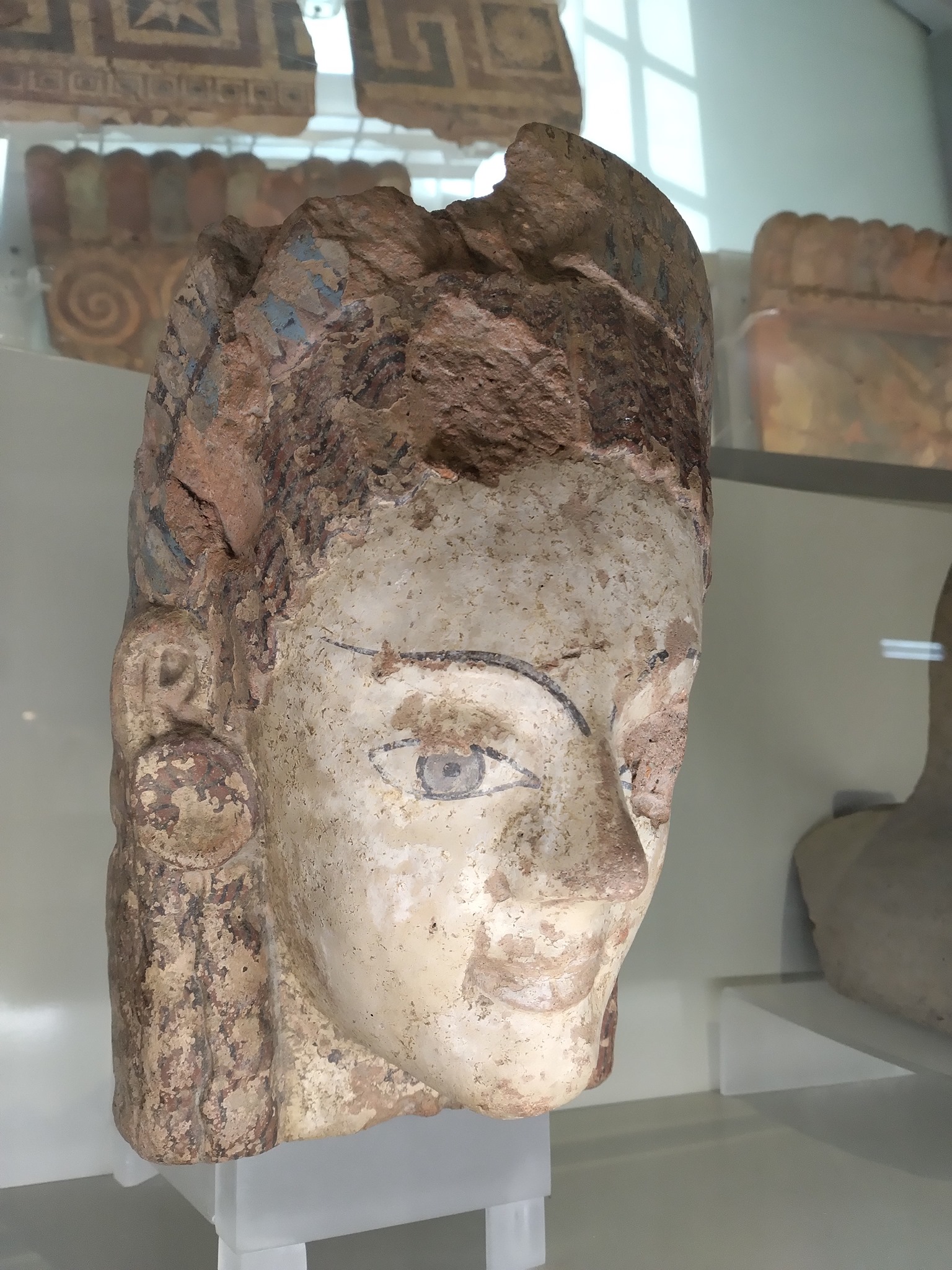 Fig. 1, Antefissa a testa femminile in terracotta lavorata a stampo e dipinta (tipo Winter 6.C.4.b) da Cerveteri, area urbana di Caere, 530-520 a.C., Museo Nazionale Etrusco di Villa Giulia, Roma. Non sono ancora state trovate raffigurazioni della dea, ma doveva apparire come una giovane donna